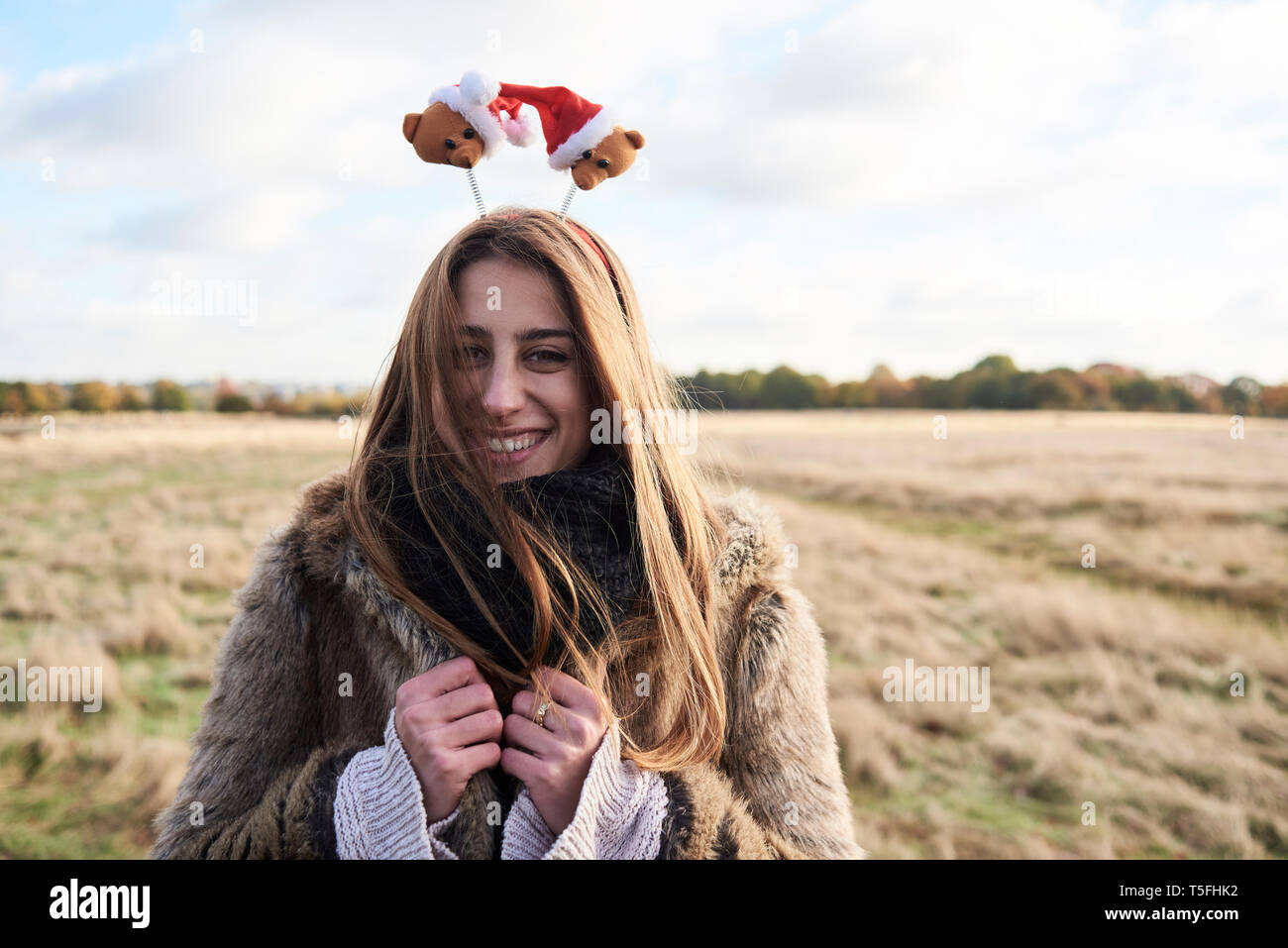 Portrait of happy young woman wearing Christmassy headdress in the countryside Stock Photo