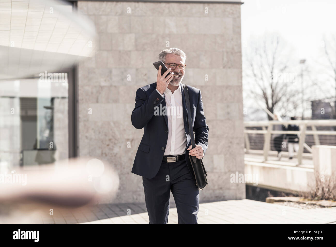 Smiling mature businessman using cell phone outdoors Stock Photo - Alamy
