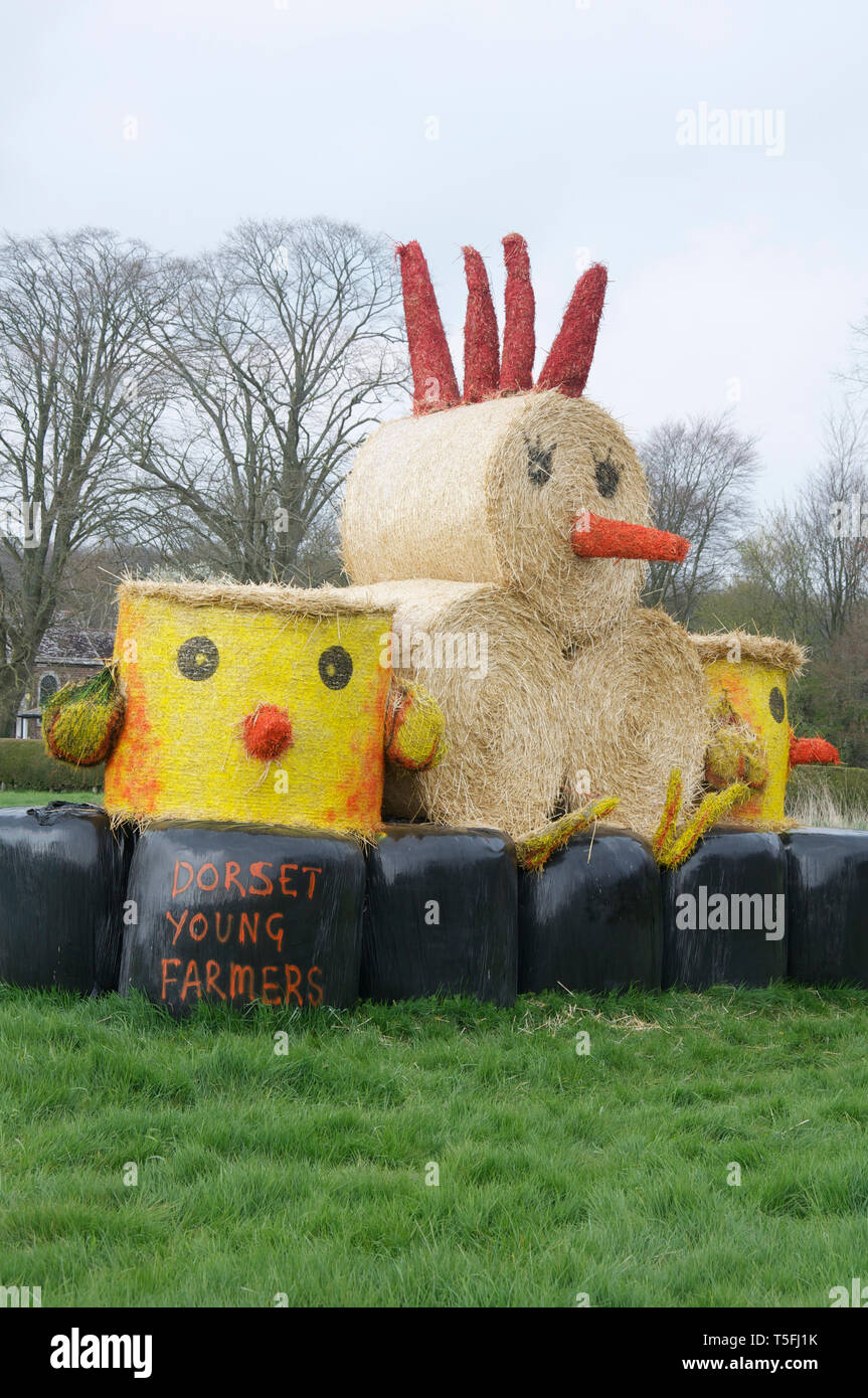 Quirky, comical Easter construction, representing a hen and its chicks made out of hay bales, arranged in a field in Dorset, England, United Kingdom. Stock Photo