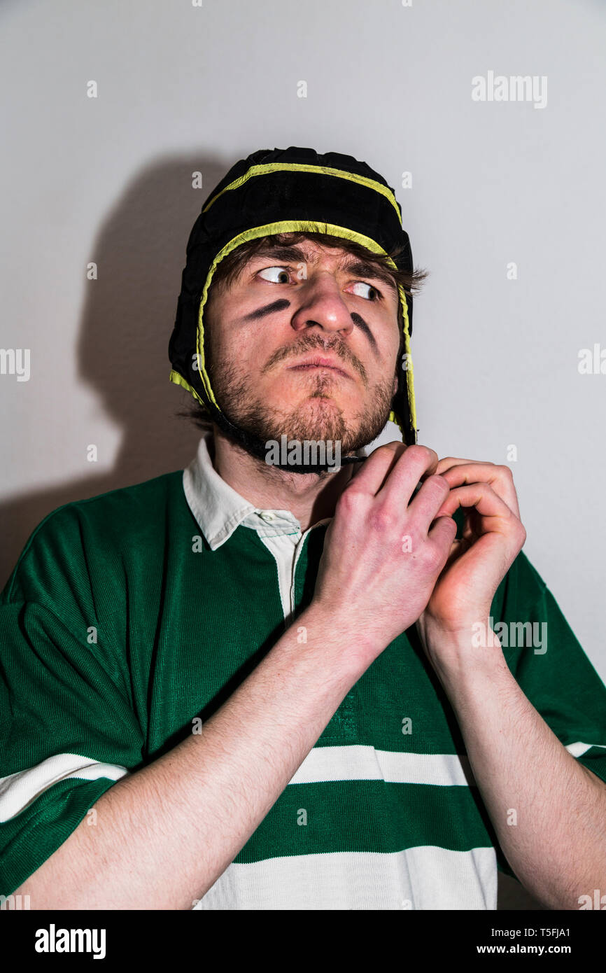 Rugby sportsman puts on his head cloth helmet Stock Photo Alamy