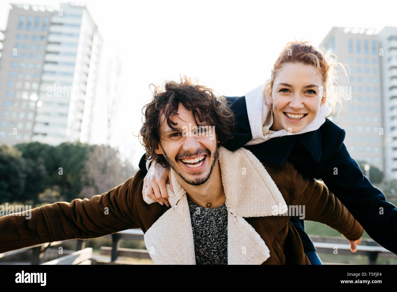 Happy couple enjoying piggyback ride in the city Stock Photo - Alamy