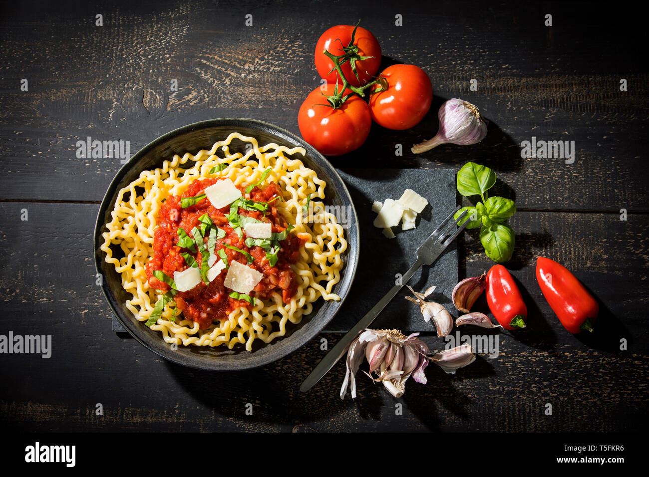 Pasta al Pomodoro, fusilli lunghi with tomato sauce, garlic, basil, parmesan cheese and red peppers Stock Photo