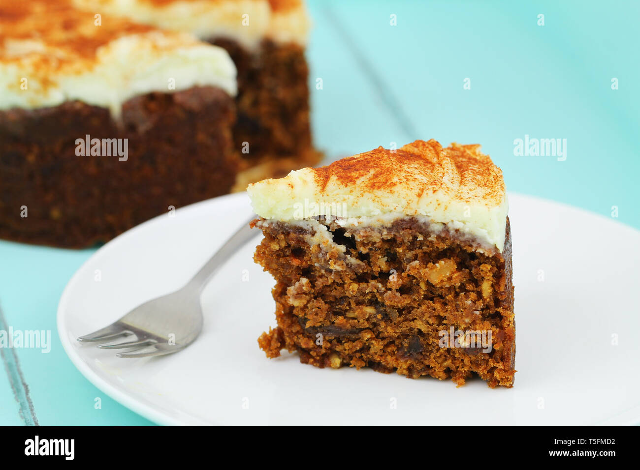 Slice of delicious carrot cake with walnuts on white plate Stock Photo