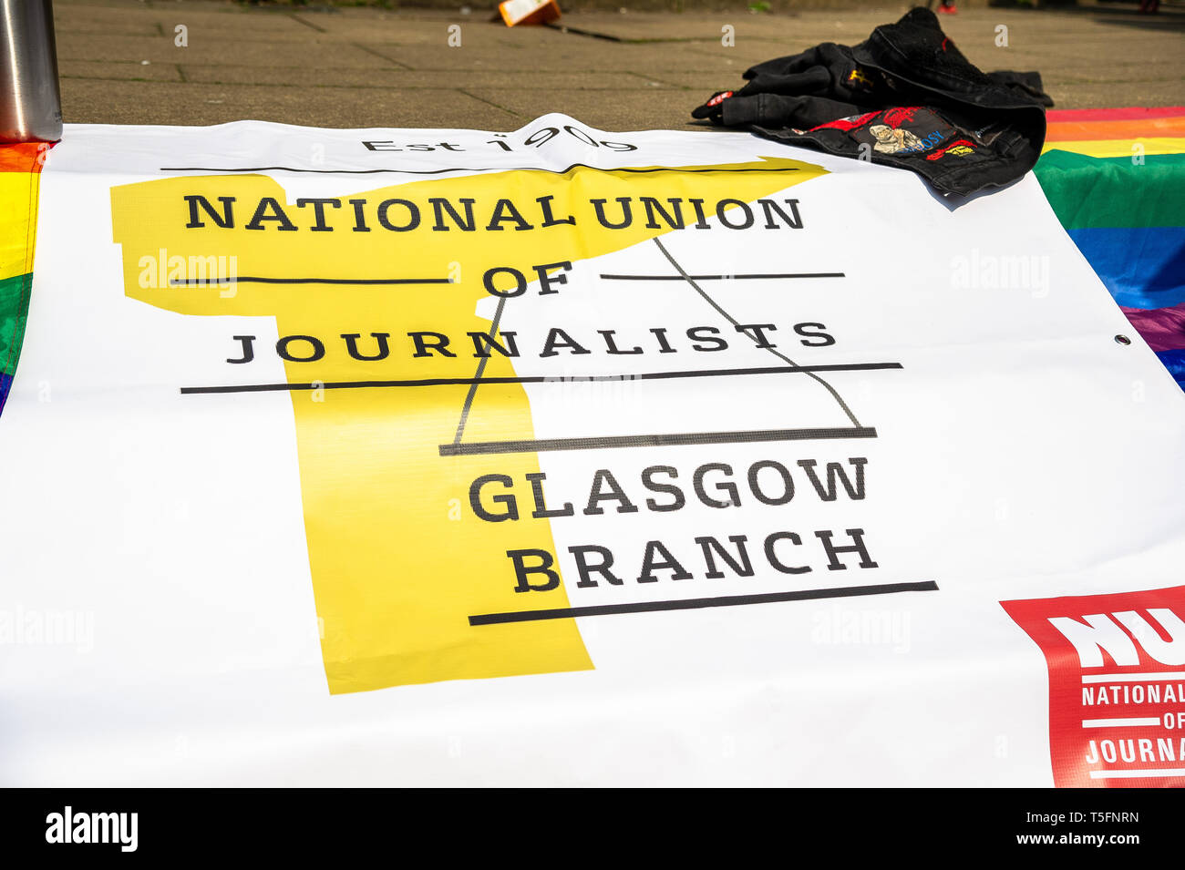 The flag that was used by the NUJ seen laying on the ground during the vigil. People turned out to pay their respects to the Belfast born journalist Lyra McKee, 29, who was shot dead by members of the New IRA whilst while covering riots that were happening in Derry, also known as Londonderry. The NUJ Glasgow branch held a vigil for those wishing to pay their respects for the slain journalist. Stock Photo