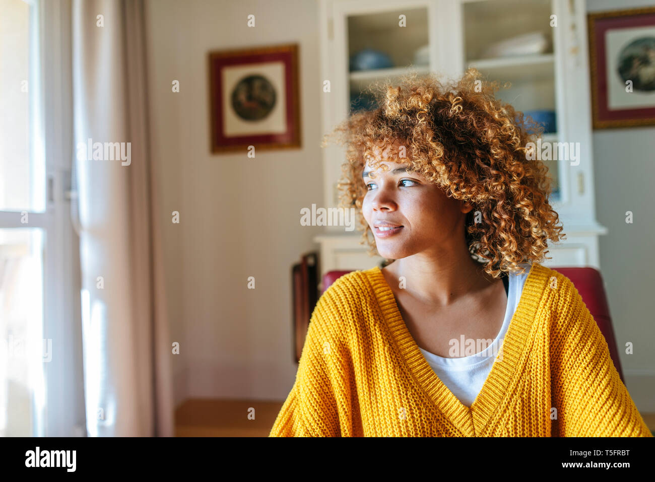 Young woman with curly hair at home Stock Photo