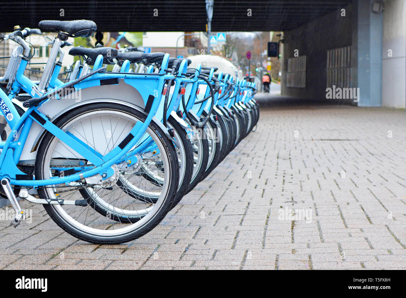 Many blue temporary rental bikes from German transport association of the Rhein-Neckar region called 'Nextbike' in a row at parking station Stock Photo