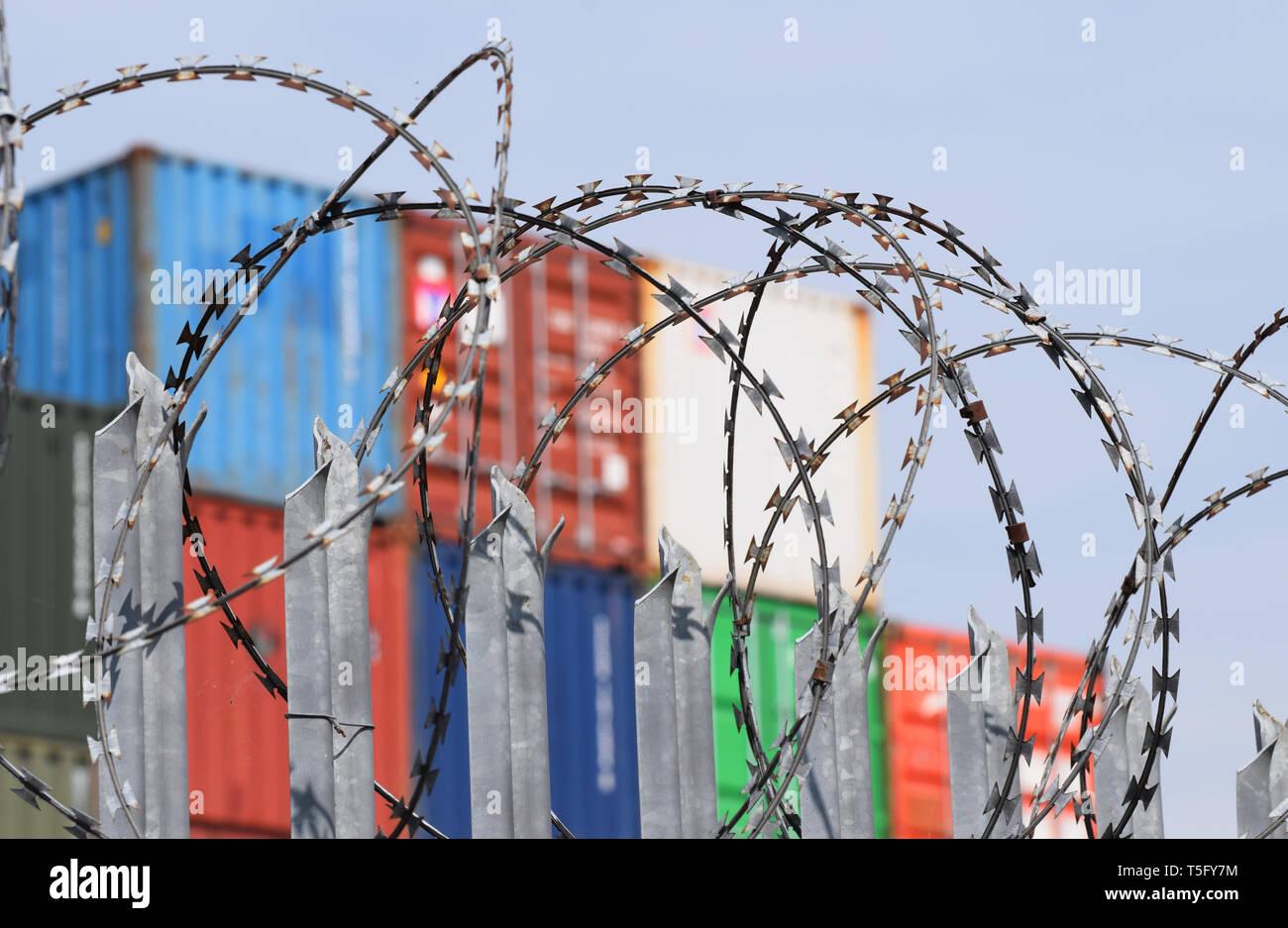 Freight Shipping Containers behind barbed wire at one of the UK's busiest commercial ports. A good potential image for trade barriers or hard border Stock Photo