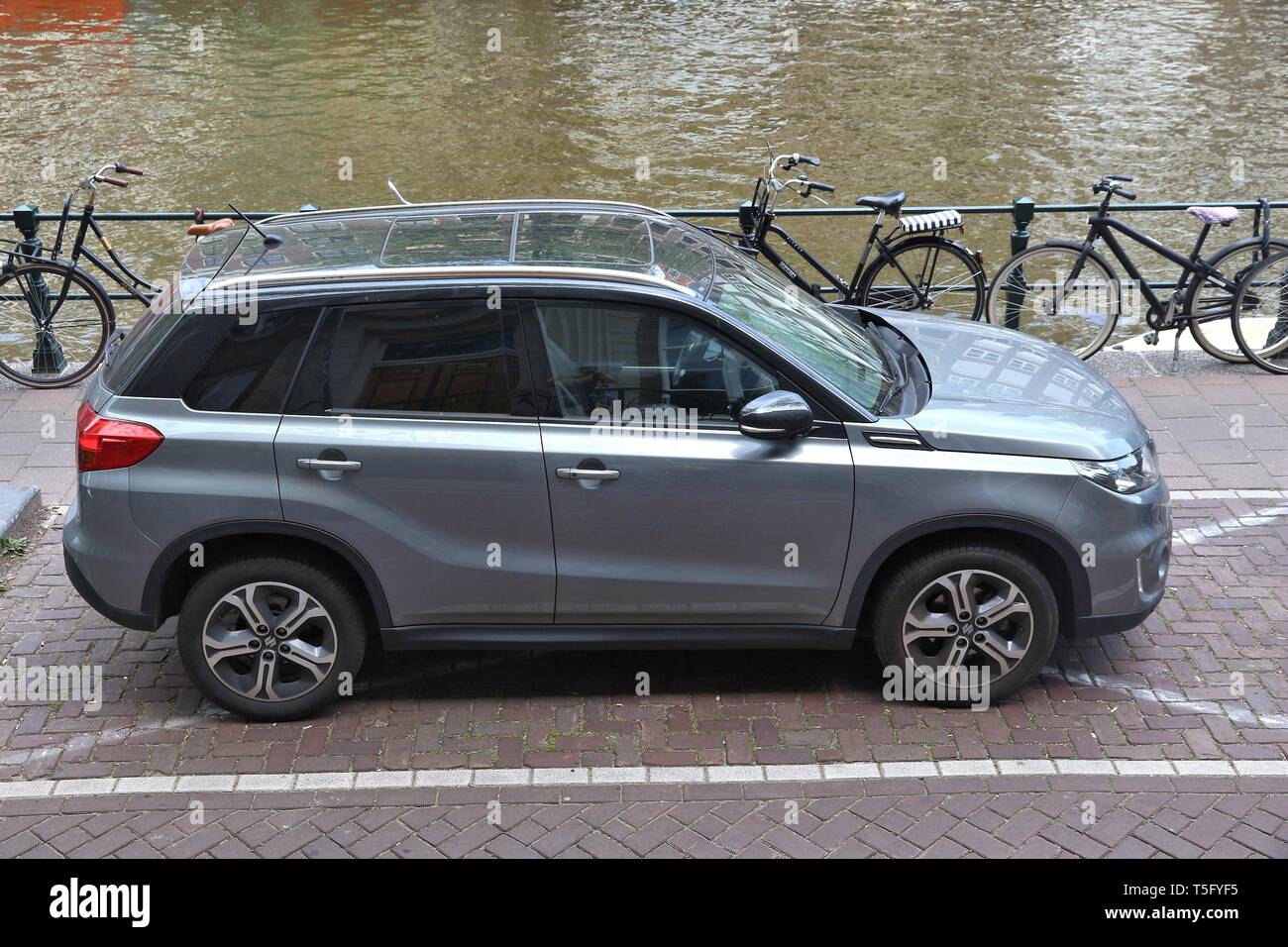 AMSTERDAM, NETHERLANDS - JULY 10, 2017: Silver Suzuki Grand Vitara SUV parked by the canal in Amsterdam. Netherlands has 528 registered cars per 1,000 Stock Photo