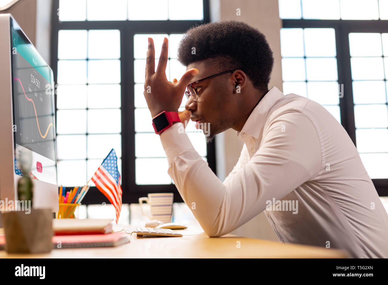 Unhappy young man looking at the financial statistics Stock Photo