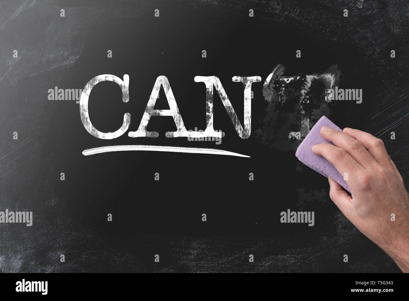 changing CAN’T to CAN by erasing letter T with blackboard eraser, motivation concept Stock Photo