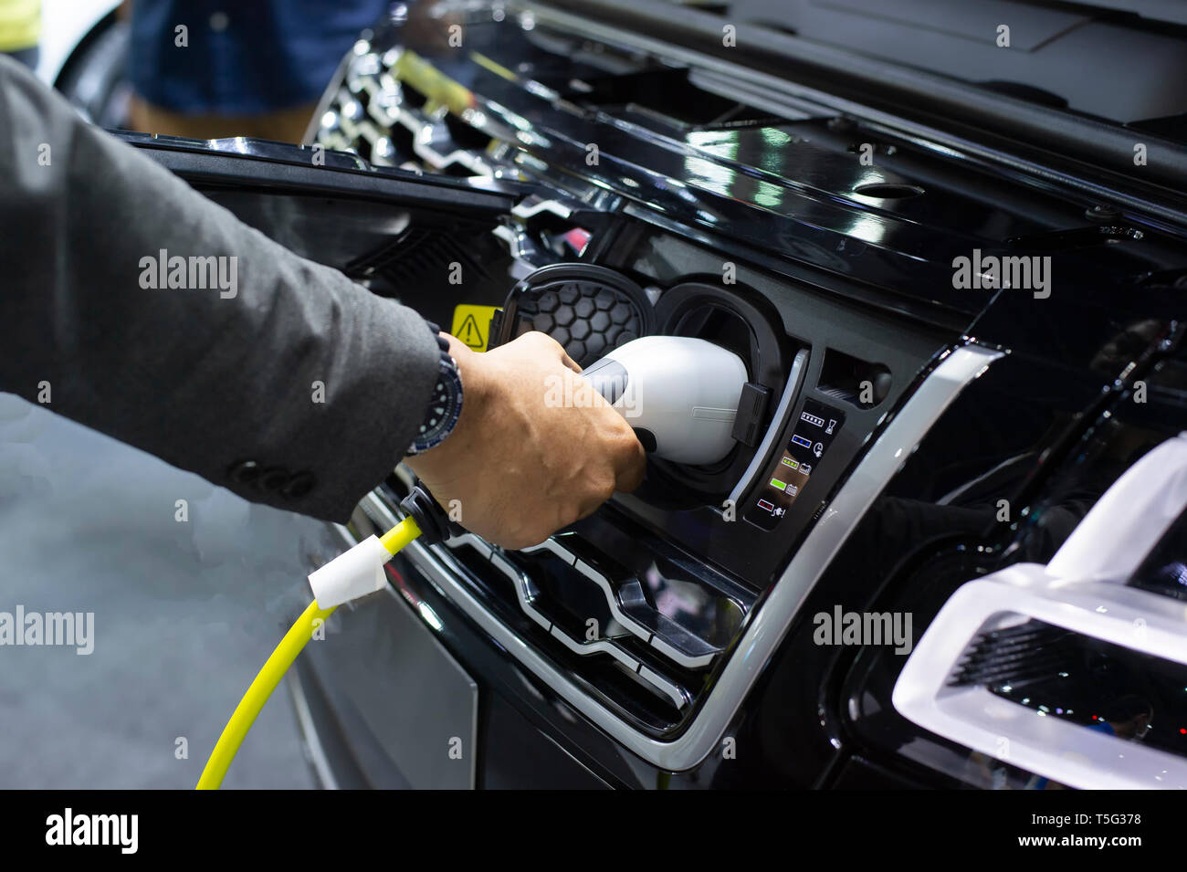Electric vehicle is plugged into electricity. Battery in car and auto