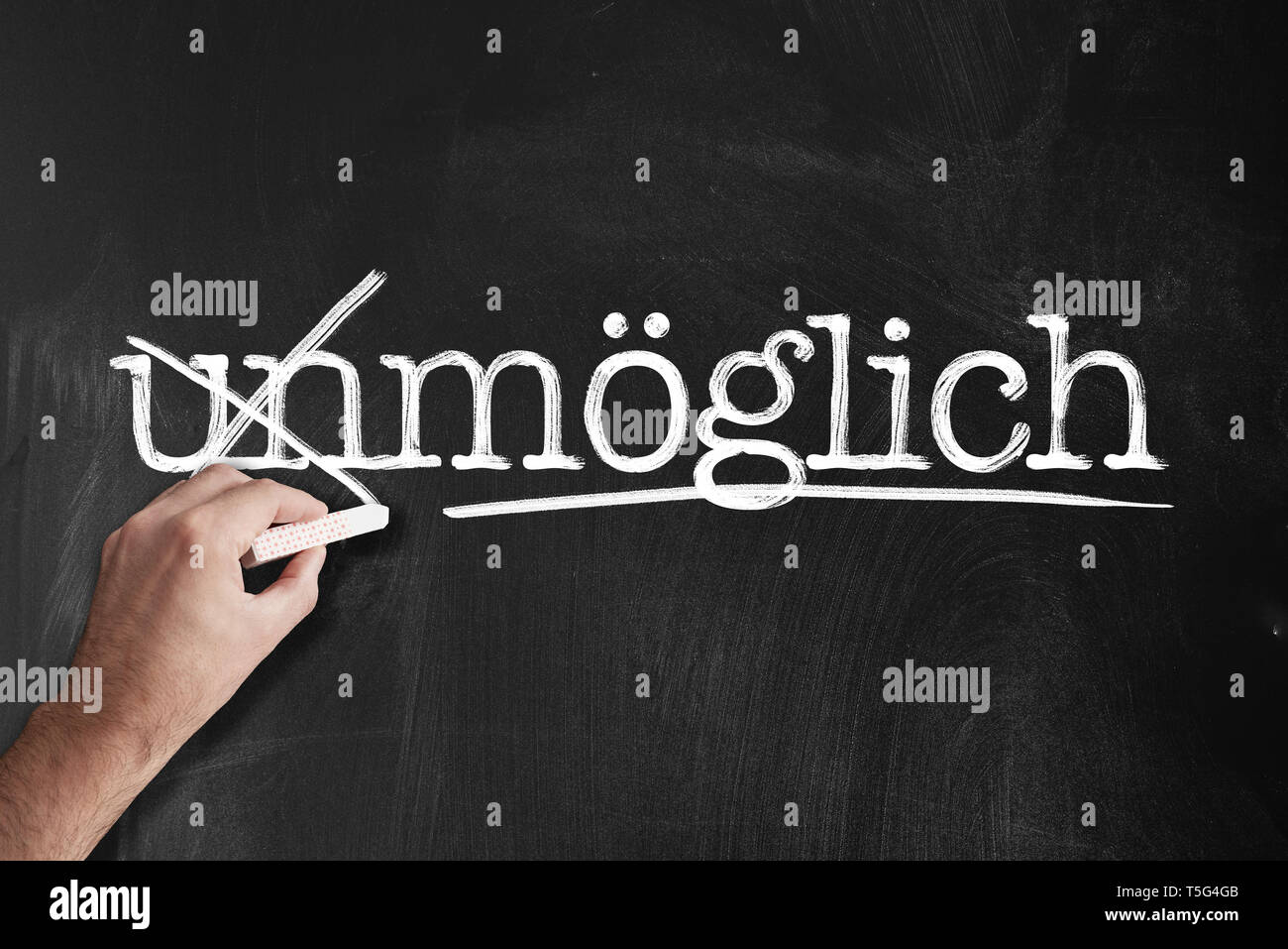 changing word unmöglich to möglich, German for impossible and possible, on chalkboard motivation concept Stock Photo