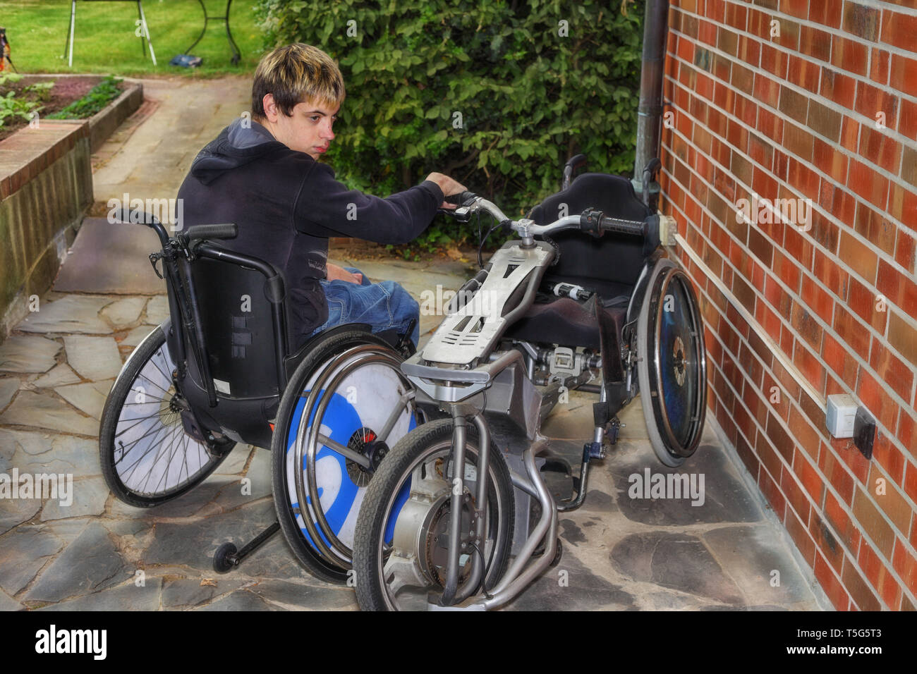Handicapped boy with a special electric drive for a wheelchair. Stock Photo