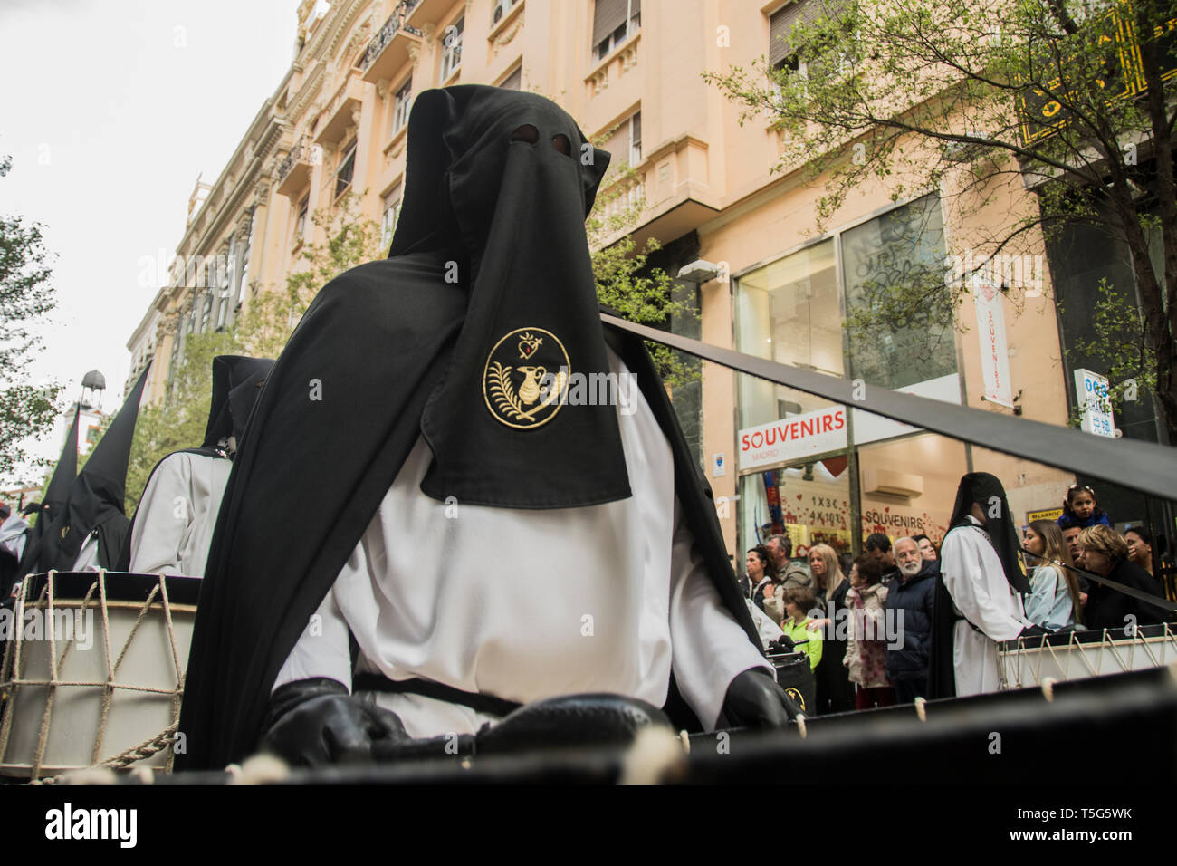 A hooded man seen with a big drum on the procession of our lady of loneliness in Madrid, Spain. Procession of our lady of loneliness and helplessness, Stock Photo