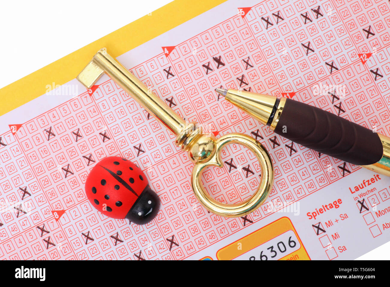 Lottery - A filled lottery ticket with pen and luck symbols. Stock Photo