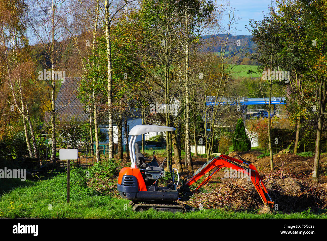 Excavator on a building plot with shield - for sale Stock Photo