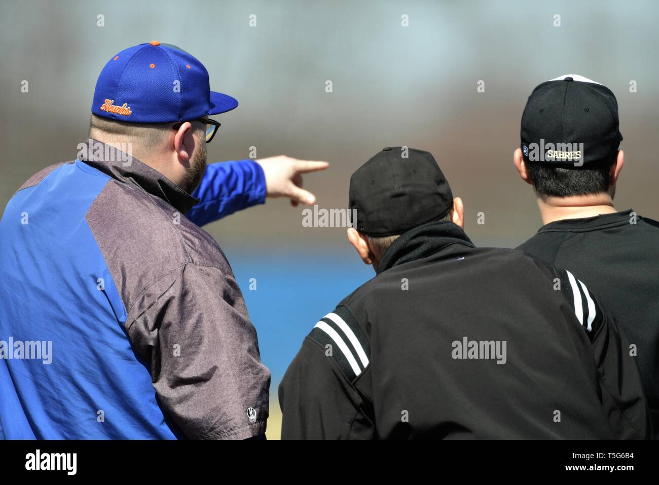 Coach meeting with umpires to go over the ground rules in a pregame discussion at home plate. USA. Stock Photo