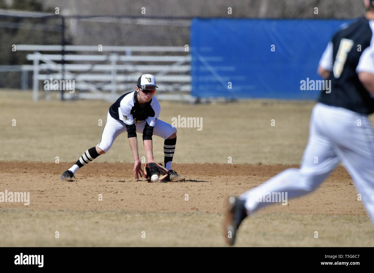 Second baseman fielding a ground ball before throwing on to first base to retire the hitter. USA. Stock Photo
