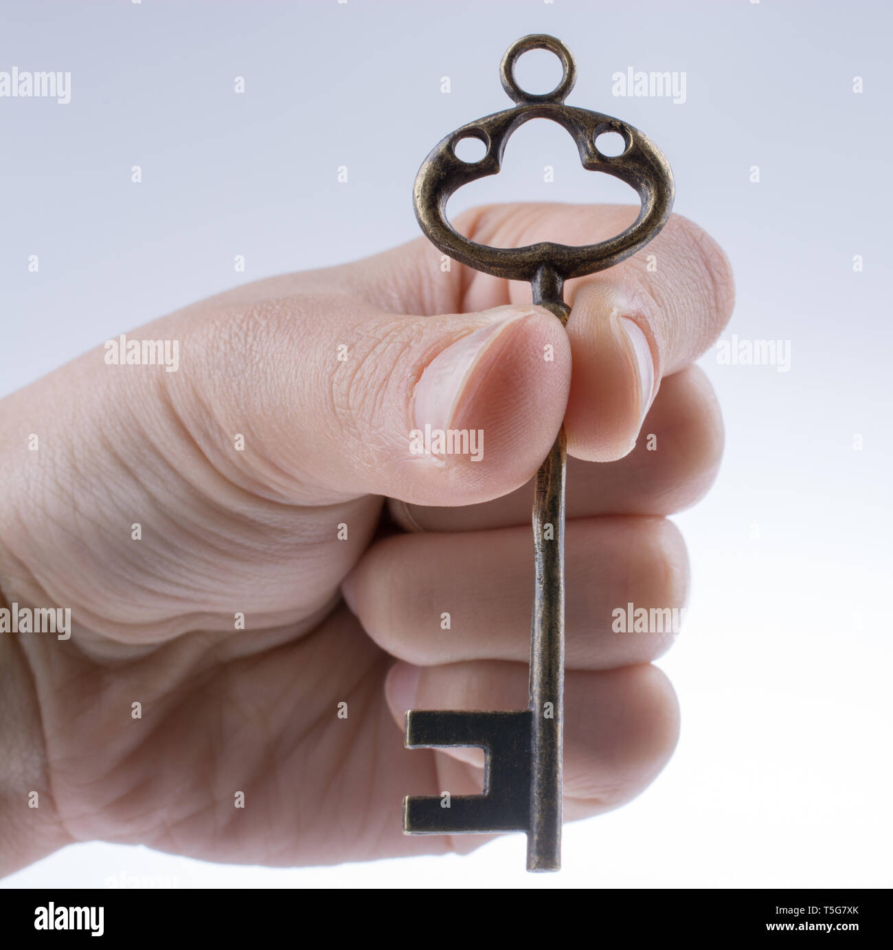 hand holding a retro styled metal key on a white background Stock Photo ...