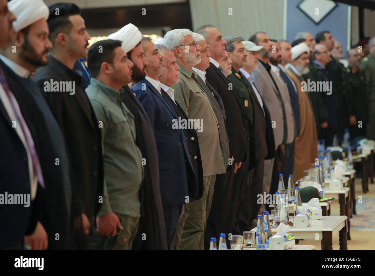 Baghdad, Iraq. 24th Apr, 2019. Hadi Al-Amiri (7-L), former Iraqi minister of transportation and Leader of the Fatah Alliance, Abu Mahdi al-Muhandis (8-L), Iraqi-Iranian military commander of the Popular Mobilization Forces (PMF), Falih Alfayyadh (9-L), PMF chairman, and Iraqi former Prime Minister Haider al-Abadi (11-L) attend a conference organized by the predominantly Shia Muslim Popular Mobilization Forces to honour Iranian fighters who died fighting the so-called Islamic State (IS) terror group. Credit: Ameer Al Mohammedaw/dpa/Alamy Live News Stock Photo