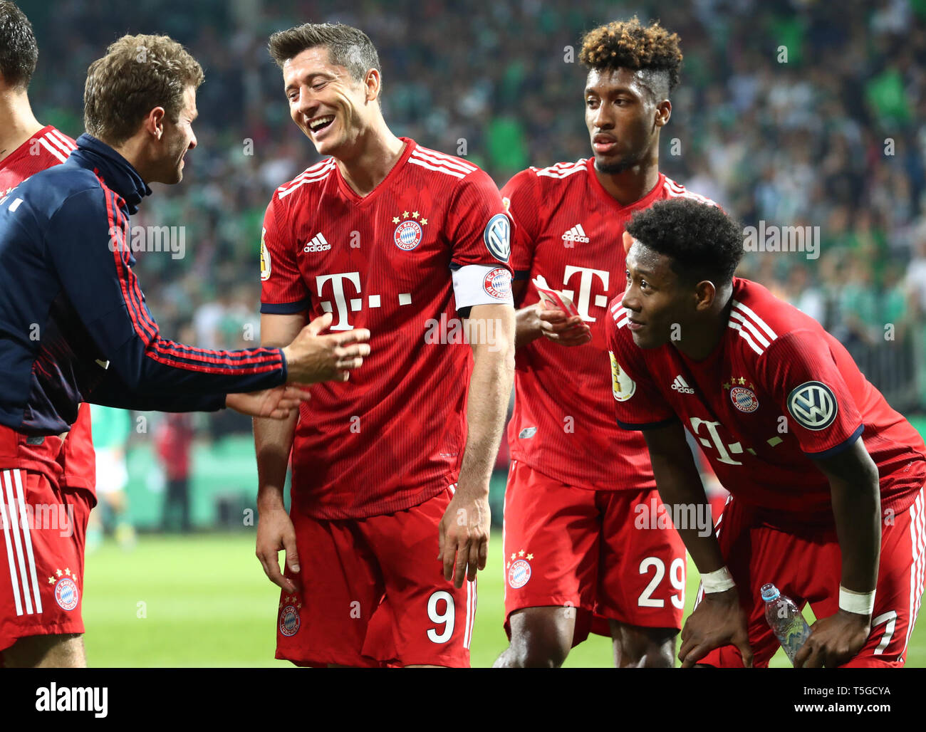 24 April 2019, Bremen: Soccer: DFB Cup, semi-final: Werder Bremen - FC Bayern Munich in the Weserstadion. Munich's Thomas Müller (l) and Robert Lewandowski (2nd from l) cheer after the match about the victory while Kingsley Coman and David Alaba (r) listen to the two scorers (Important note: The DFB prohibits the use of sequence images on the Internet and in online media during the match (including half time). Blocking period! The DFB permits the publication and further use of images on mobile devices (especially MMS) and via DVB-H and DMB only after the end of the game.) Photo: Christian Char Stock Photo