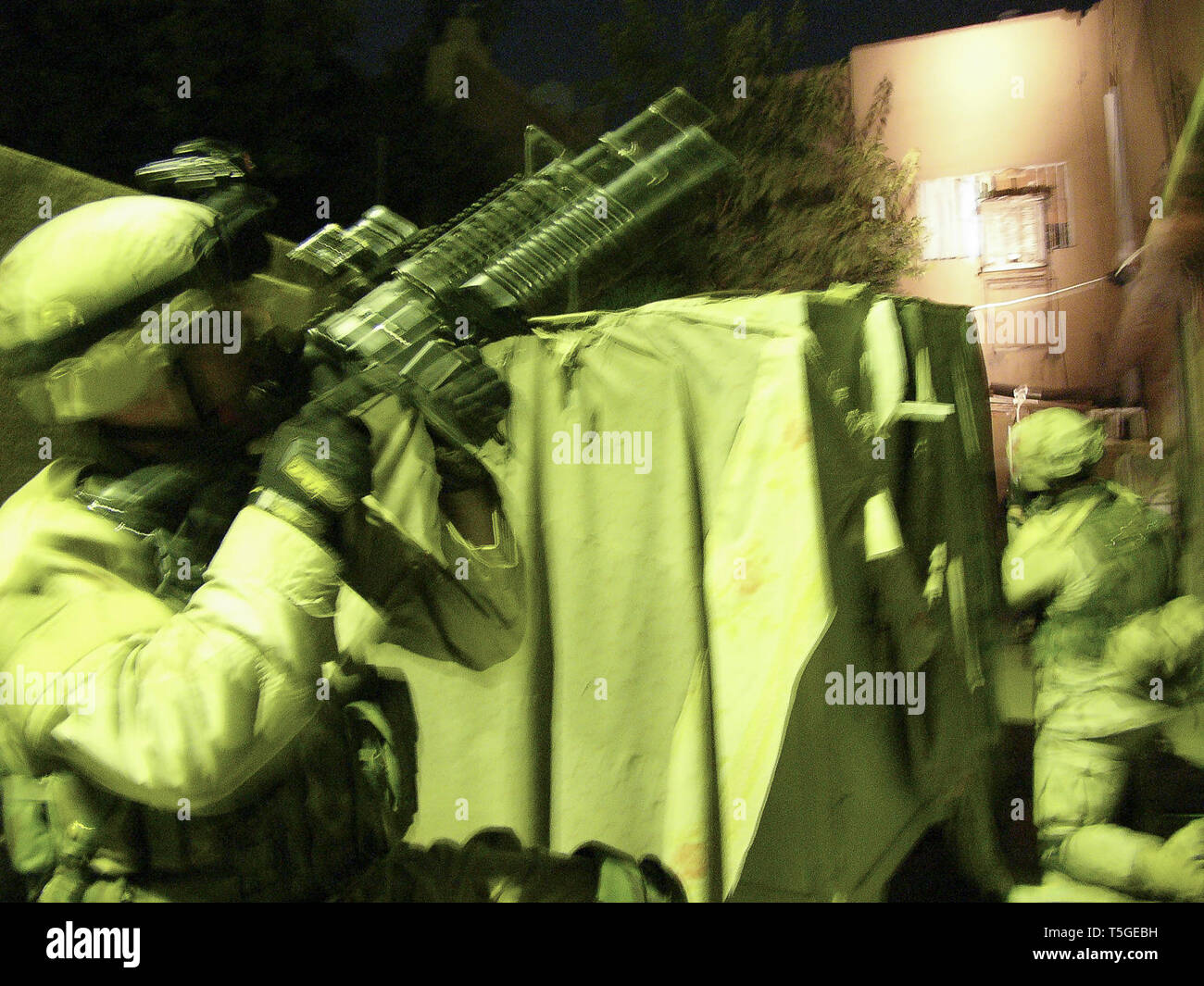 Baghdad, Baghdad, Iraq. 7th Nov, 2004. Soldiers from Charlie Troop, 1st Squadron, 7th Cavalry Regiment cover a house before a raid in Baghdad Nov. 7, 2004. The troop later detained two men who tested positive for recent exposure to explosive material. Credit: Bill Putnam/ZUMA Wire/Alamy Live News Stock Photo