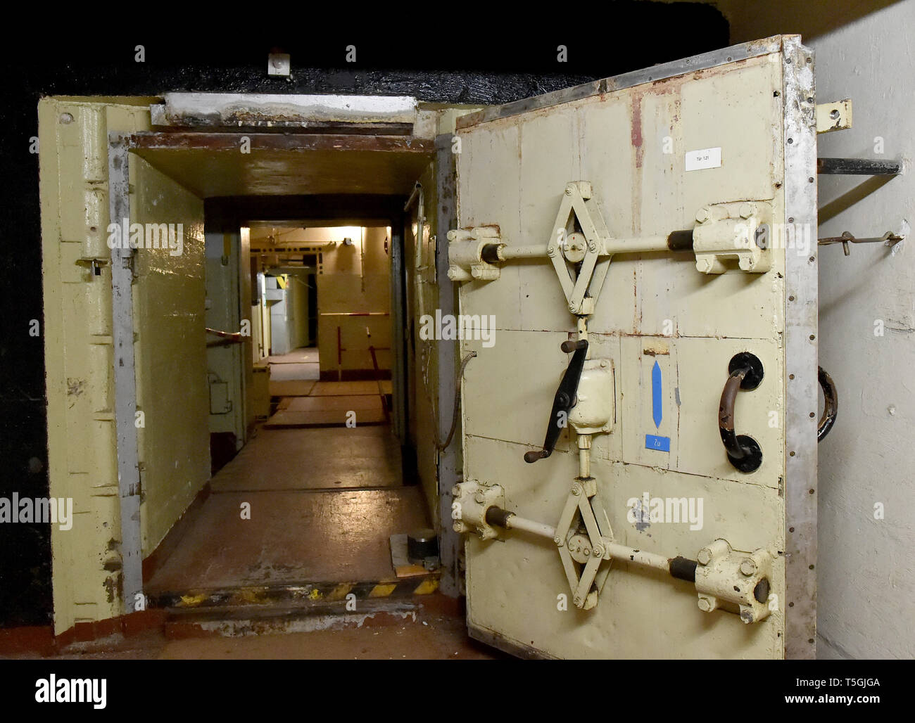 06 April 2019, Brandenburg, Prötzel Ot Harnekop: A door to the Harnekop bunker is open. On three floors 30 meters below the ground, the GDR defense minister and his high-ranking commanders wanted to entrench themselves in the event of war. The current owner has assigned the site and the bunker to various leaseholders who are in dispute over the rights of use. Photo: Bernd Settnik/dpa-Zentralbild/dpa Stock Photo