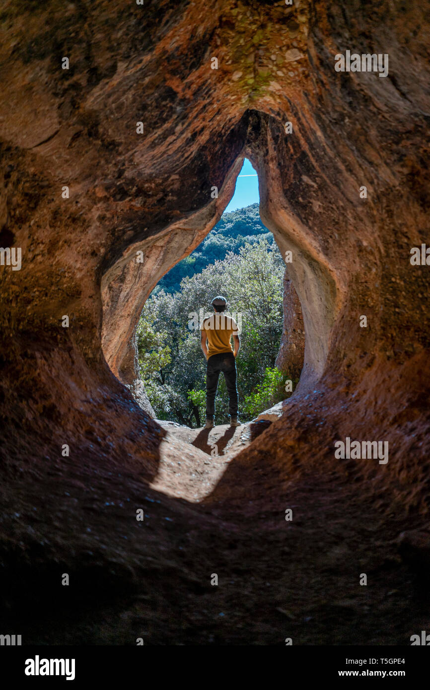 Young man standing cave entrance hires stock photography and images