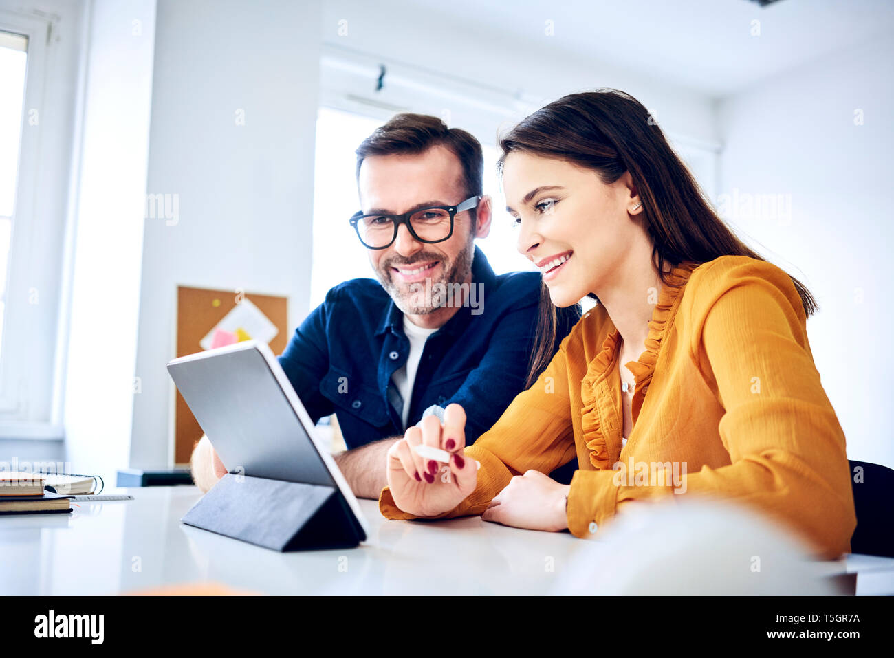 Two colleagues working together on tablet in office Stock Photo