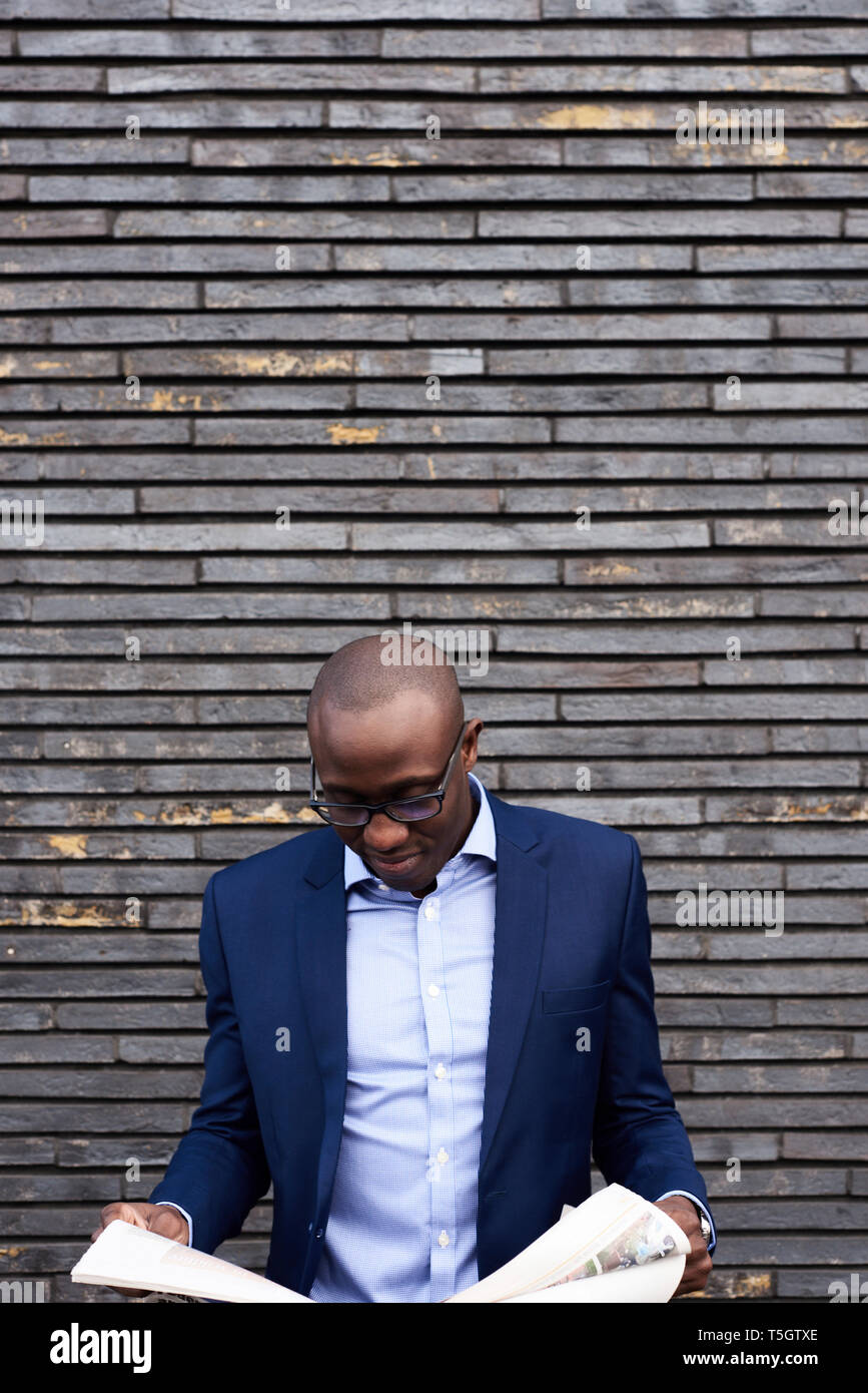 Portrait of smiling businessman wearing glasses and blue suit jacket
