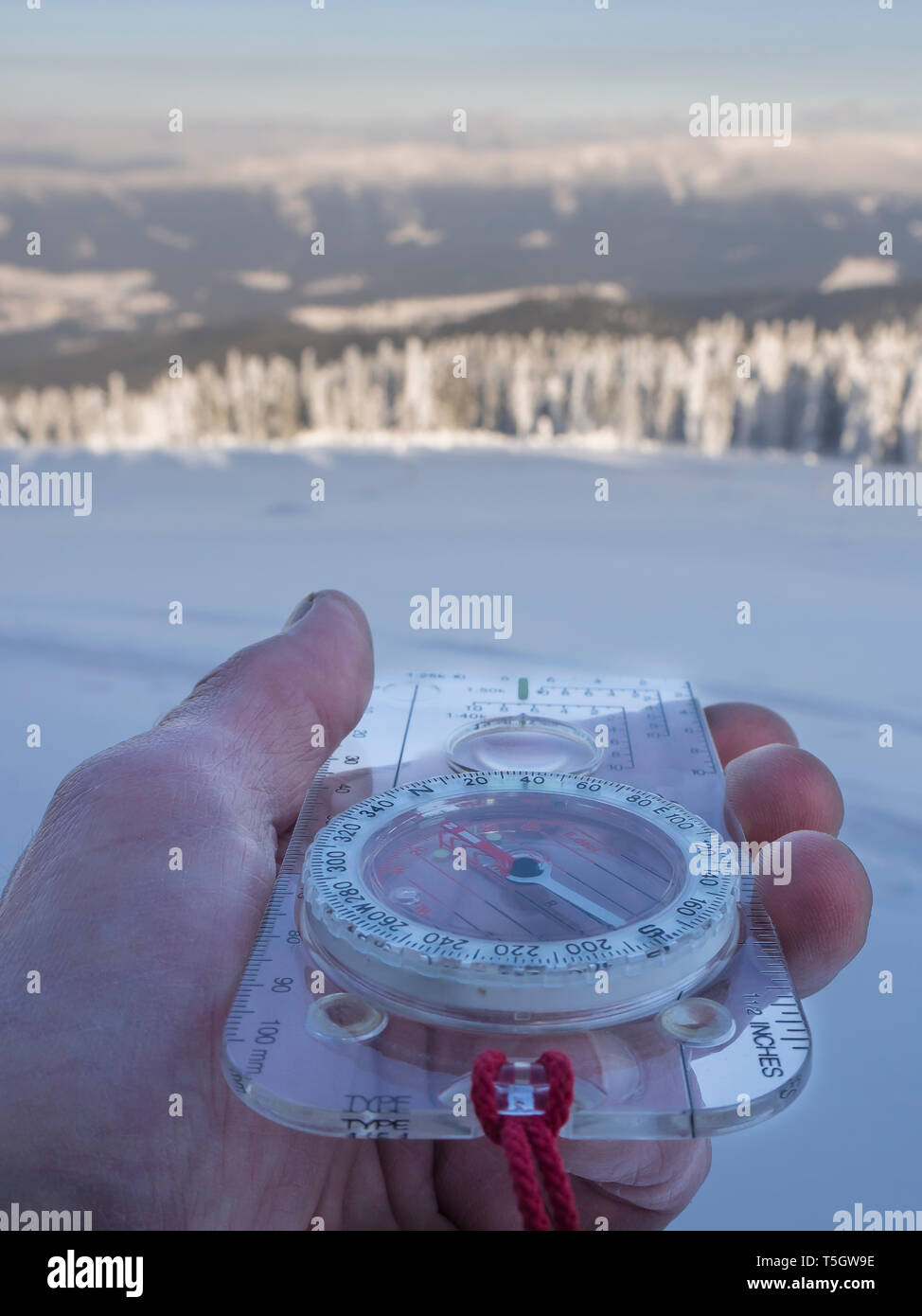 Germany, Upper Bavarian Forest Nature Park, man's hand holding compass in winter Stock Photo