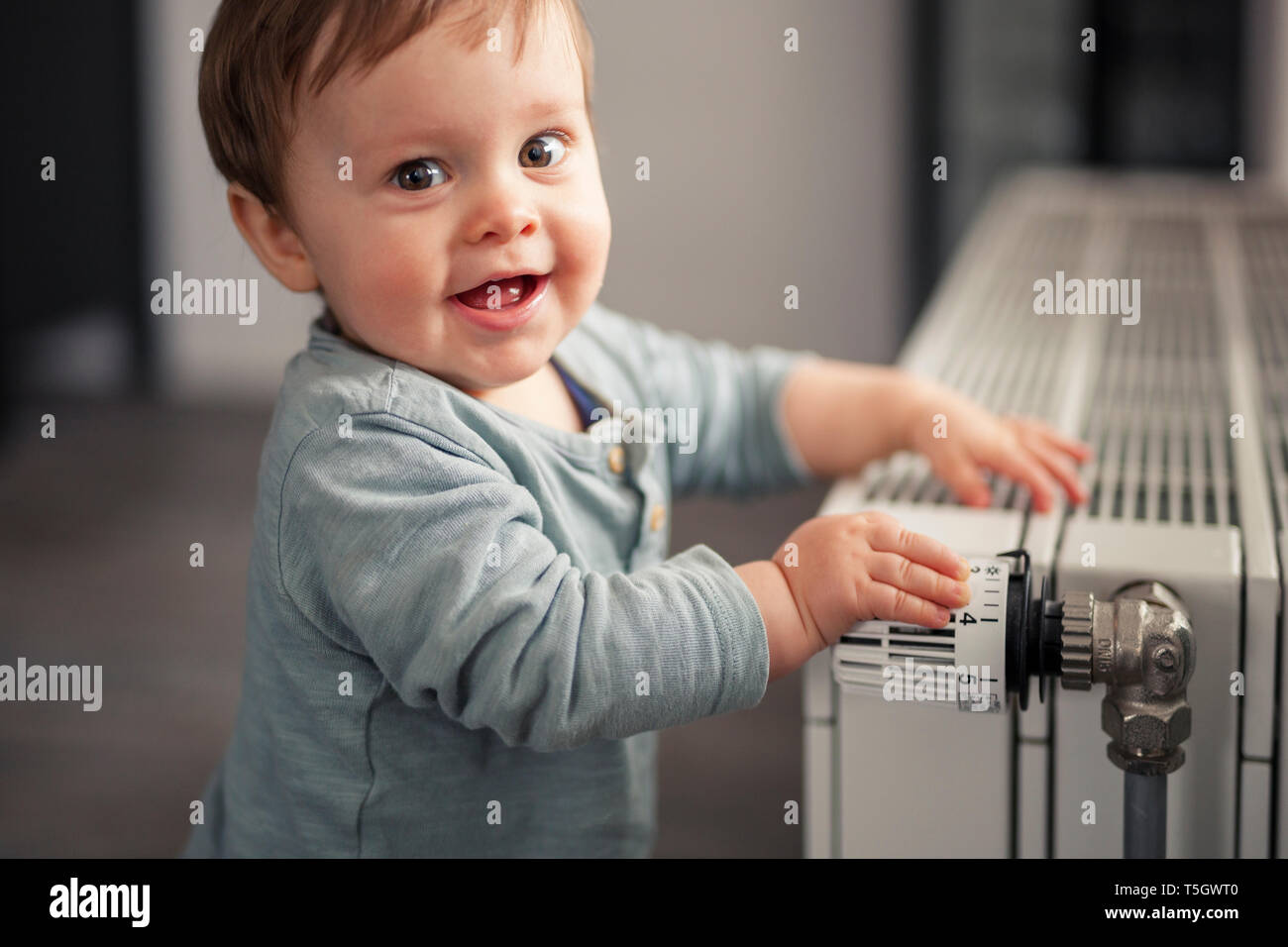 One Toddler Boy Holding Heating Thermostat On Radiator Early Child  Devlopment And Heating Costs Crisis Concept Stock Photo - Download Image  Now - iStock
