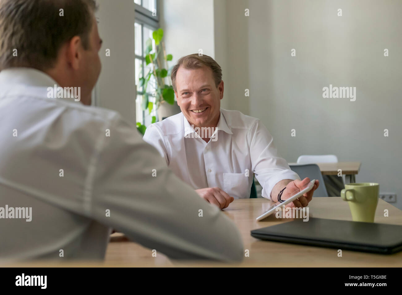 Two businessmen working with tablet in office Stock Photo