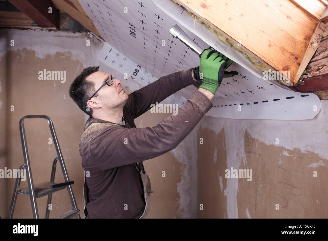 Roof insulation, worker fixing sarking membrane Stock Photo Alamy