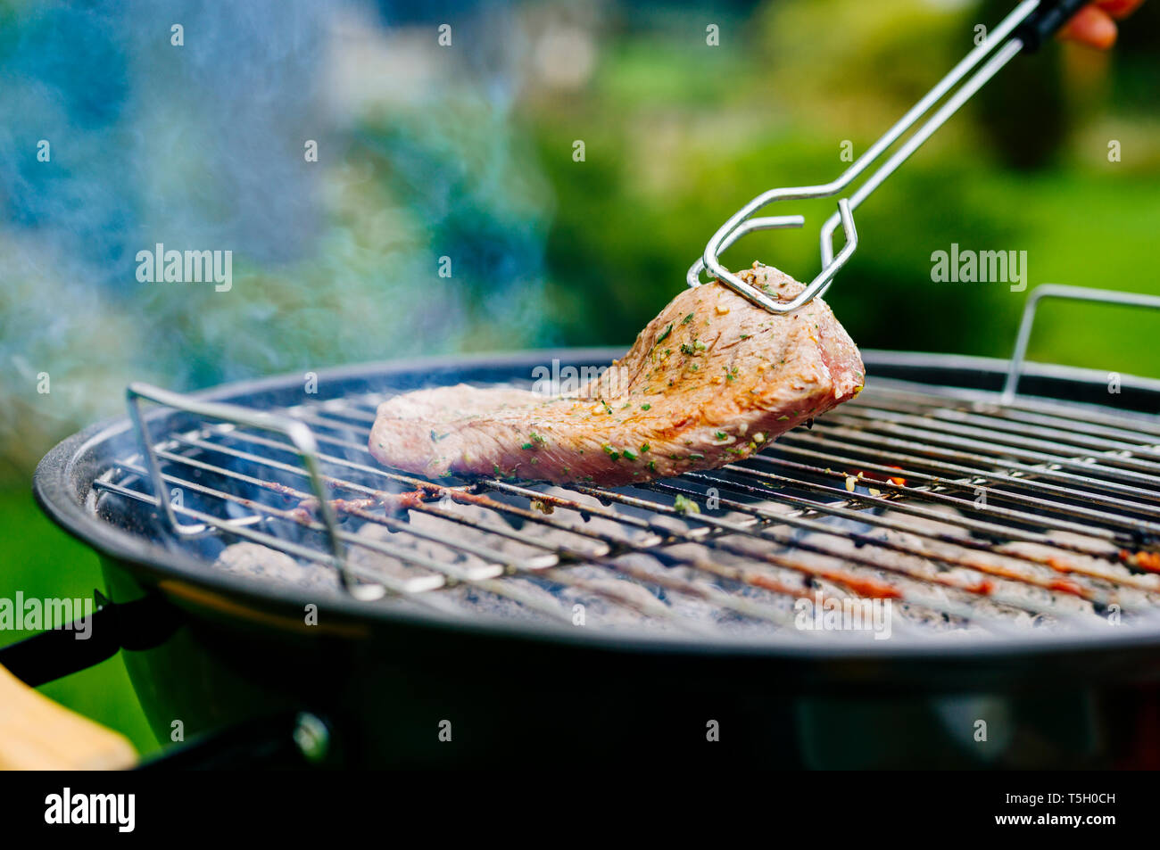 Grilling lamb fillet on charcoal grill Stock Photo