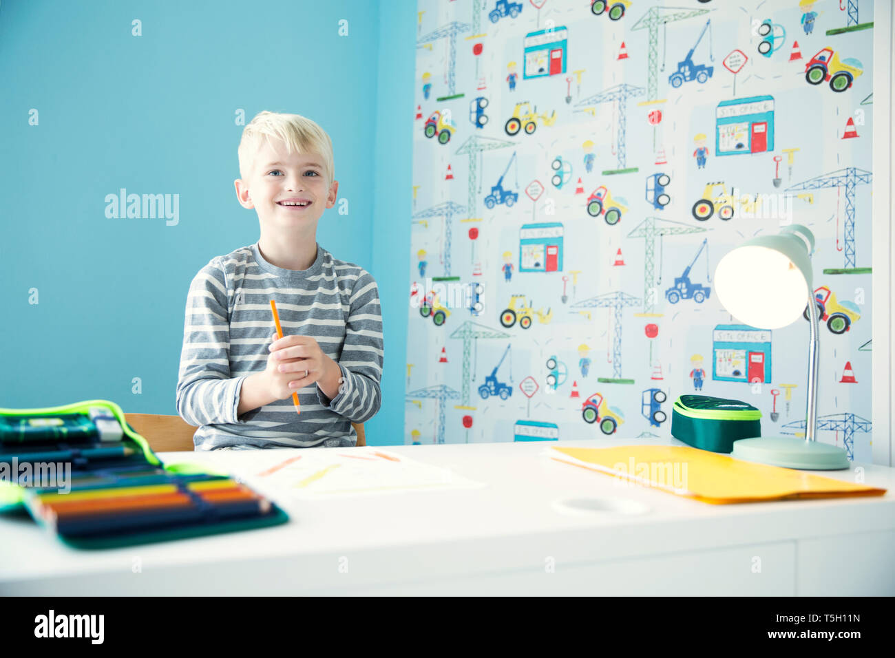 Smiling Boy Doing Homework At Desk In Children S Room Stock Photo