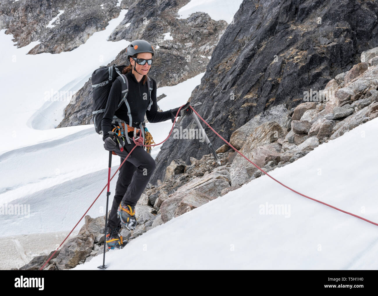 Greenland, Sermersooq, Kulusuk, Schweizerland Alps, mountaineer in snow ascending mountain Stock Photo