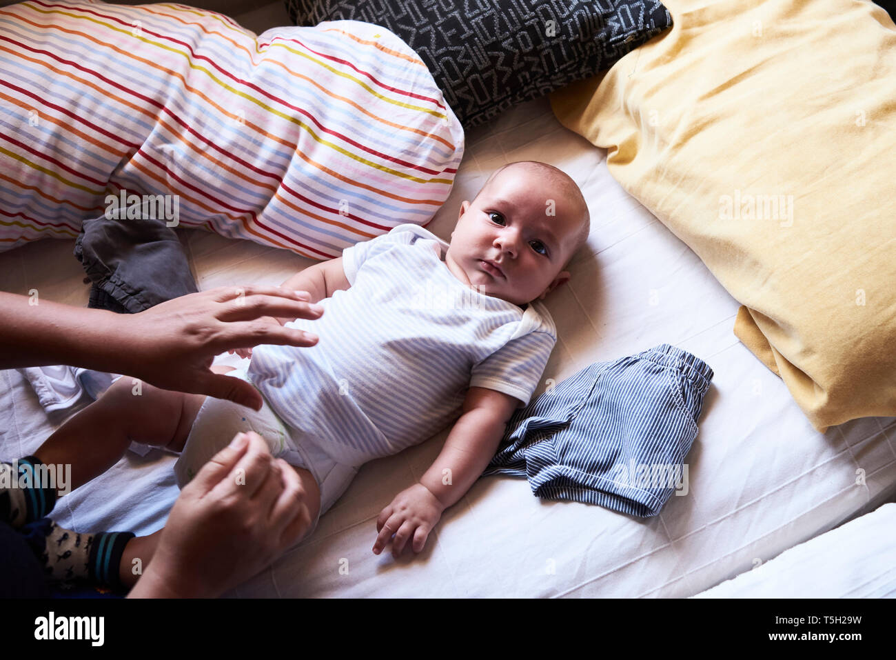 Little boy getting changed at home by mother Stock Photo
