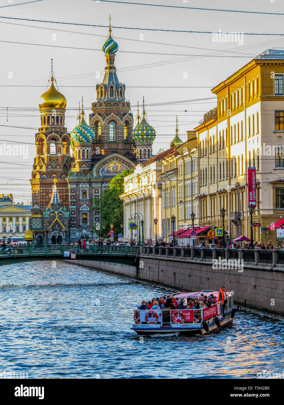 Boat with tourists on excursion on the Griboyedov Canal with the landmark Church of the Savior on Spilled Blood. St. Petersburg, Russia Stock Photo