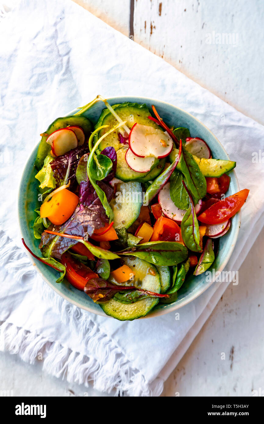 Salad with cucumber, tomato, red radish and bell pepper Stock Photo