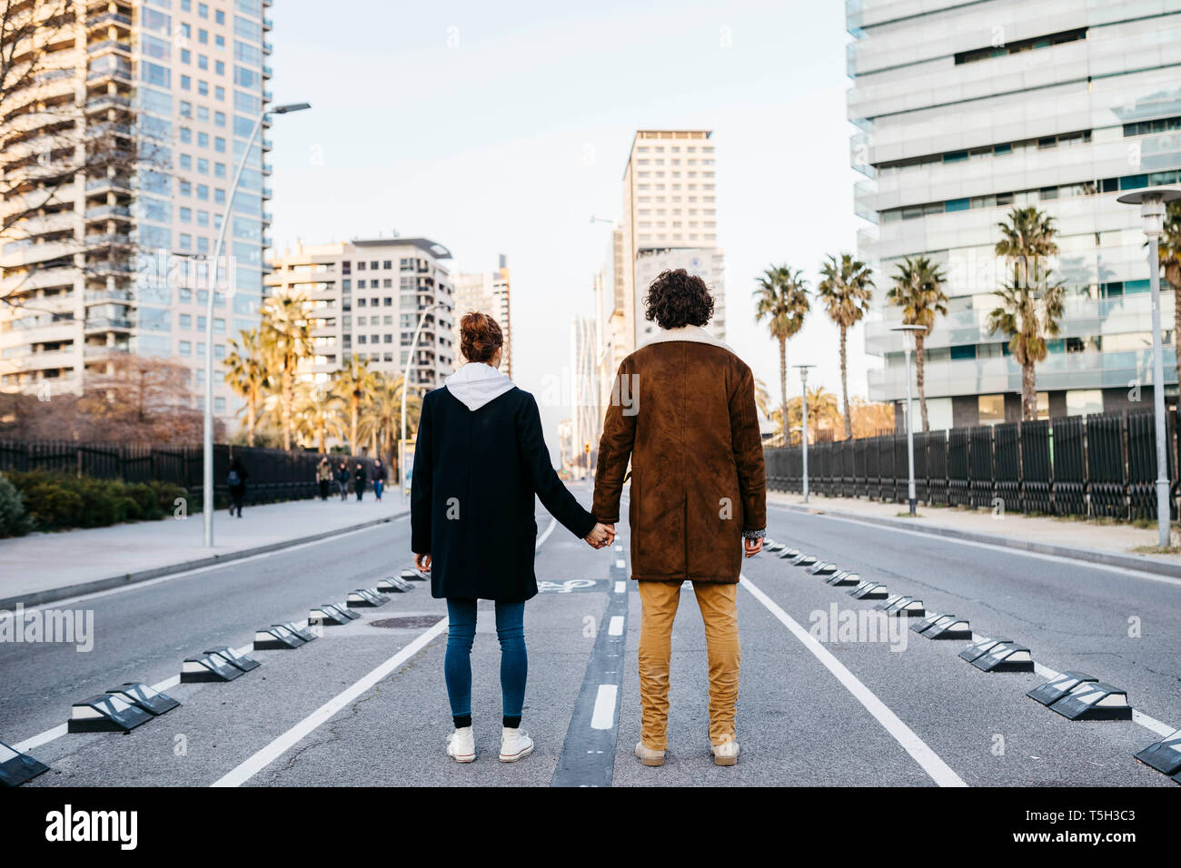 Couple holding hands rear view street hi-res stock photography and ...