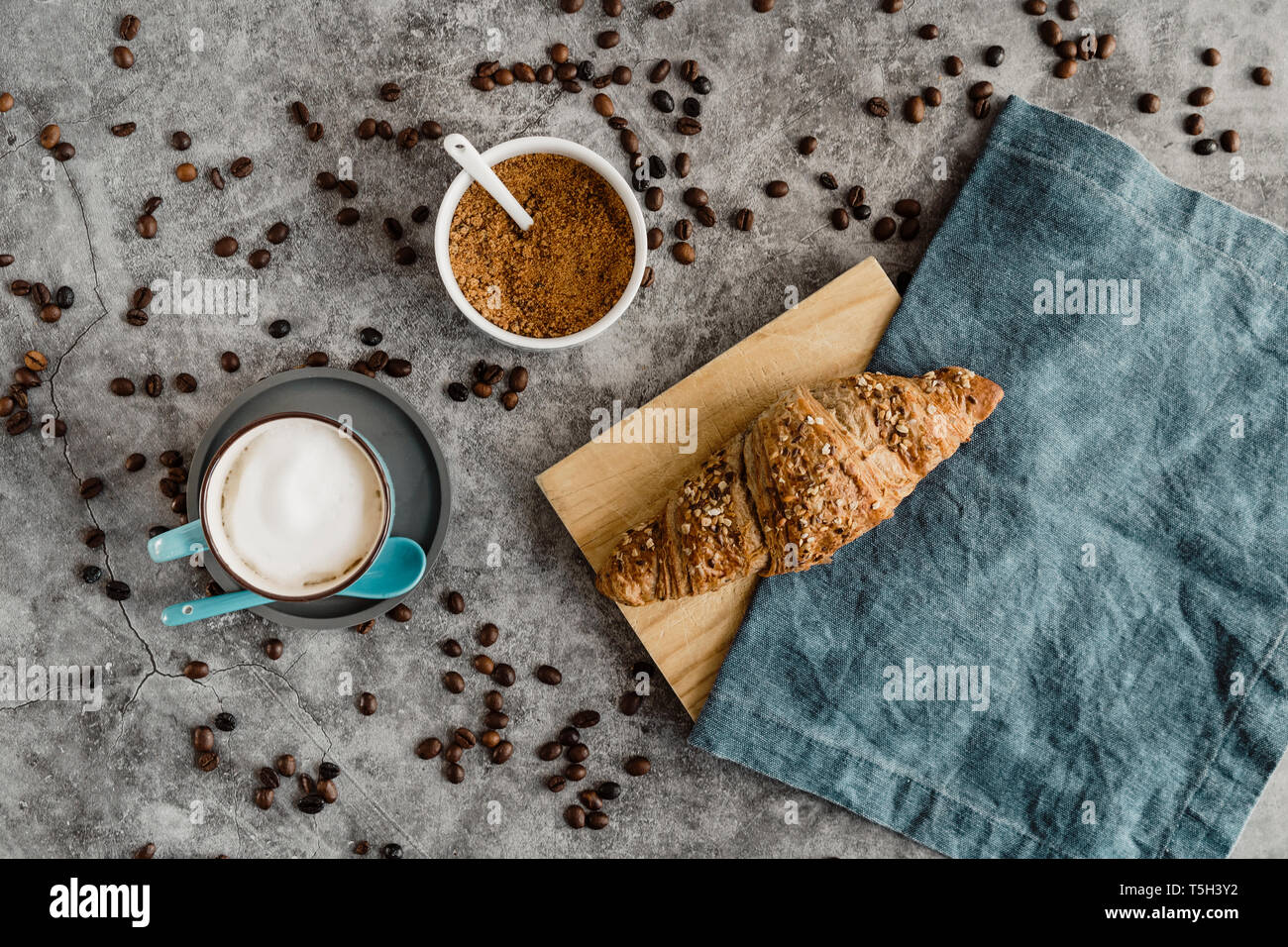 Cup of white coffee and a whole meal croissant Stock Photo