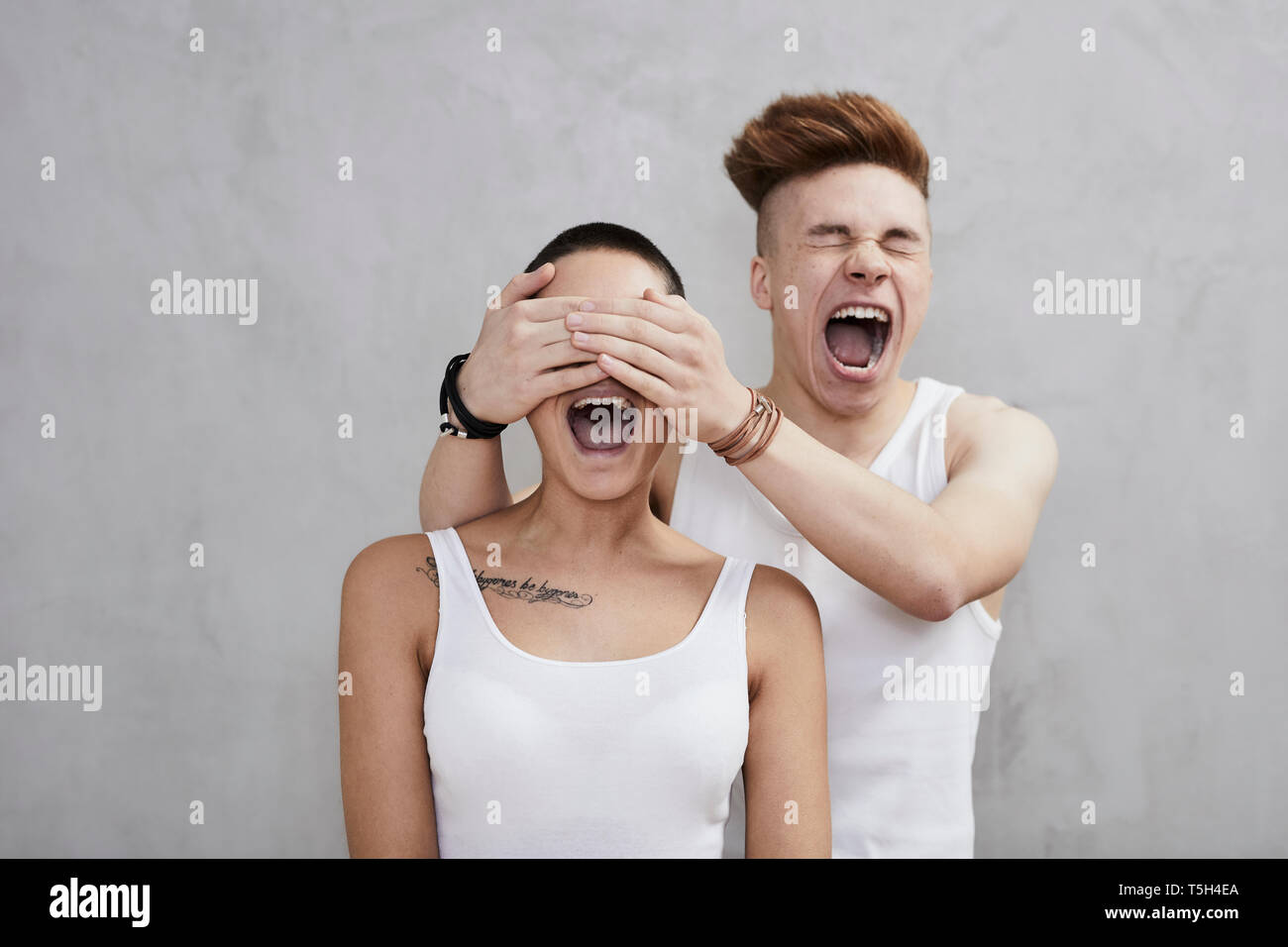 Portrait of screaming young couple wearing vests Stock Photo