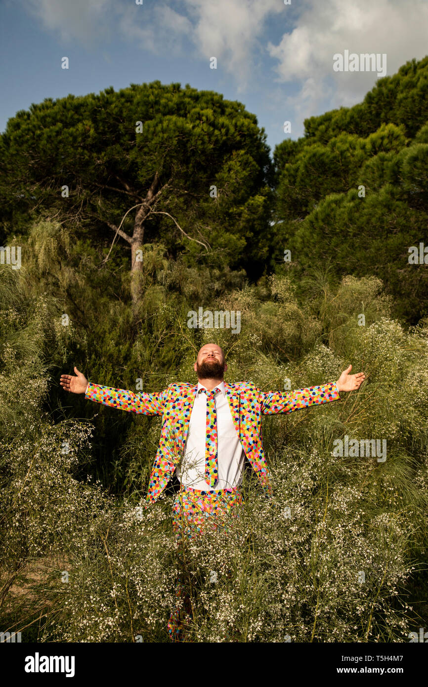 Bearded man wearing suit with colourful polka-dots enjoying nature Stock Photo