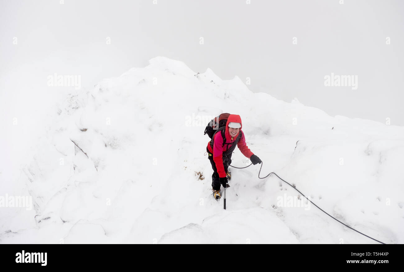 UK, Scotland, Glen Spean, woman climbing East ridge of Beinn a Caorainn in winter Stock Photo