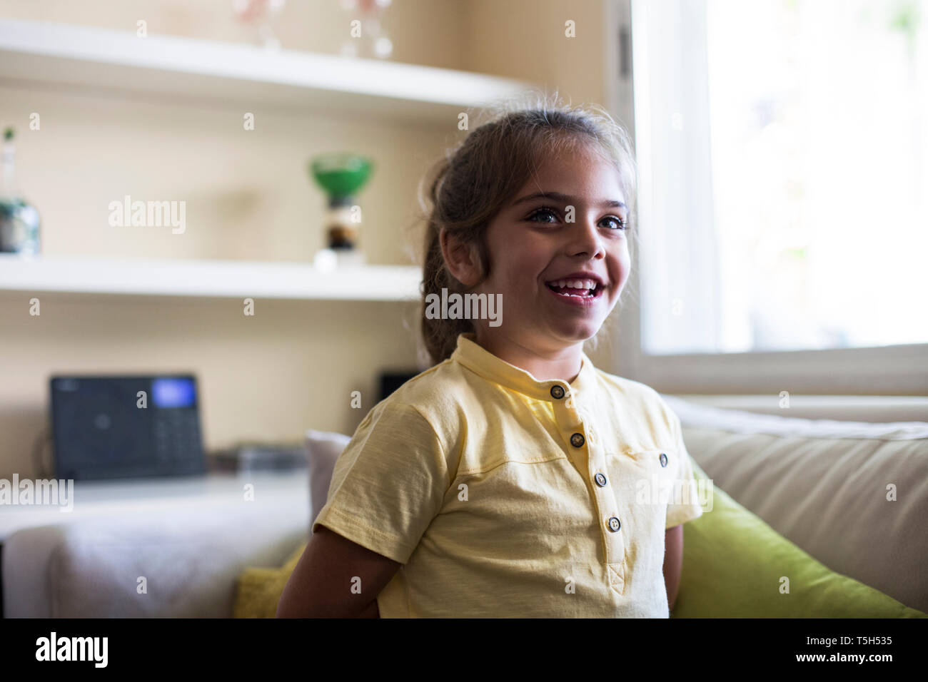 Happy little girl in living room at home Stock Photo - Alamy