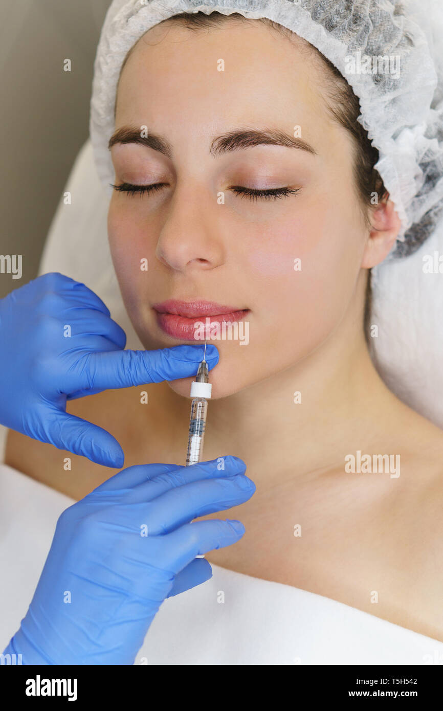 Aesthetic cosmetology. Hands of beautician make injections of