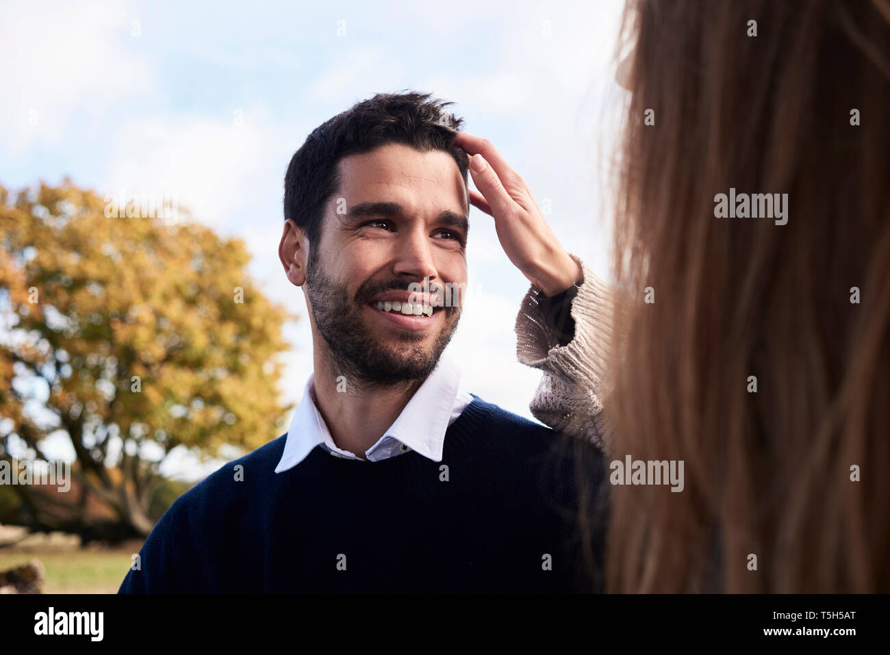 Happy man smiling at girlfriend in a park Stock Photo