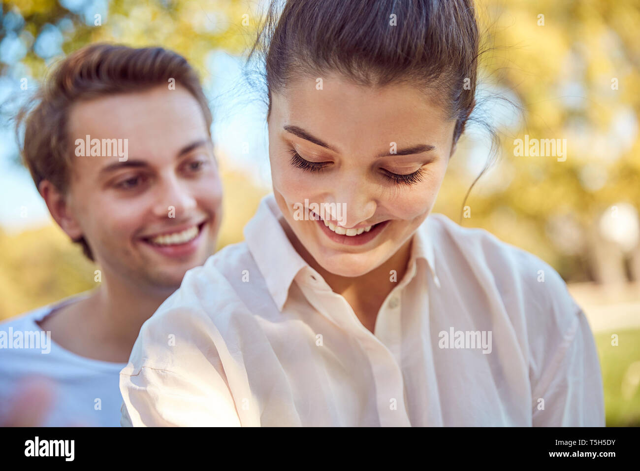 Happy young couple at a park Stock Photo - Alamy