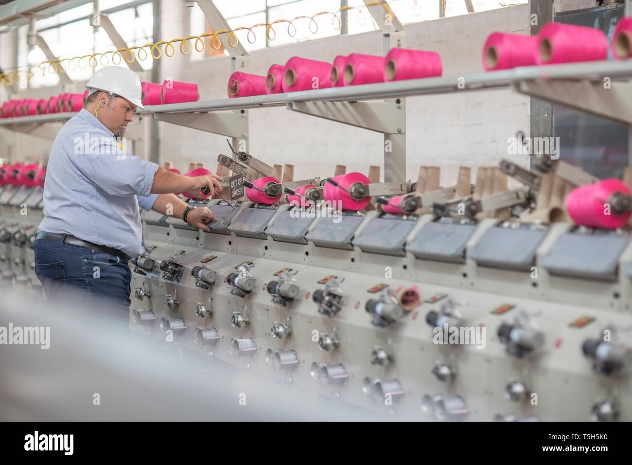 Thread Spool Operator Man working with spools in factory Stock Photo - Alamy